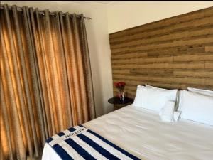 a bedroom with a large bed with a wooden headboard at Riverside guesthouse in Phalaborwa