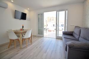 a living room with a table and a couch at Apartamentos La Siesta in Oropesa del Mar