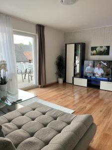 a living room with a couch and a flat screen tv at FeWo im Harz Bad Harzburg in Bad Harzburg