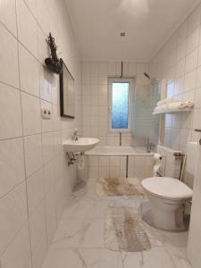 a white bathroom with a toilet and a sink at FeWo im Harz Bad Harzburg in Bad Harzburg +9 photos
