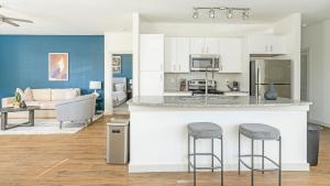 a kitchen and living room with a counter and stools at Landing at Home at Waller - Waller in Waller