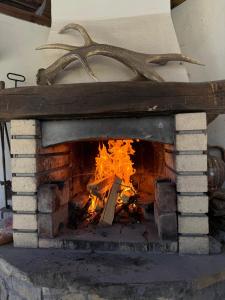 a brick fireplace with a fire in it at Vintage House in Elena