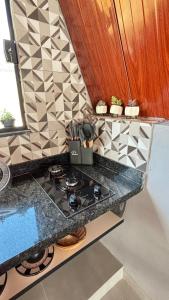 a kitchen counter top with a stove top oven at Chalé Aliança in Poços de Caldas +46 photos