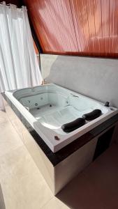 bañera blanca en una habitación en Chalé Aliança, en Poços de Caldas