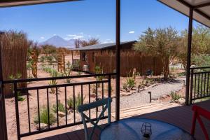 a room with a balcony with a view of a yard at Luna de Chañares in San Pedro de Atacama
