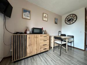 ein Zimmer mit Fernseher und Schreibtisch mit Tisch in der Unterkunft Studio au cœur du Praz-de-Lys - Les Pralyssimes in Le Praz de Lys + 15 Fotos