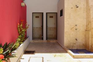 a hallway with two doors in a red wall at Hotel MX portal maya in Playa del Carmen