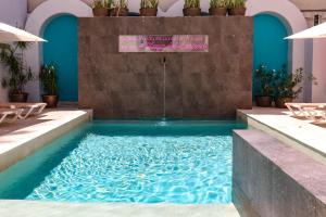 a swimming pool in a building with blue water at Hotel MX portal maya in Playa del Carmen