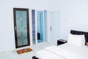 a bedroom with a white bed and a window at Palace Executive Suites in Tamale