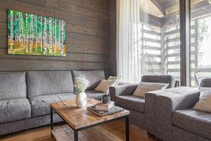 a living room with a couch and a table at Villa Kultaranta A - Scenic Lakeside Cabin in Tahkovuori with Hot Tub and Sauna in Tahkovuori