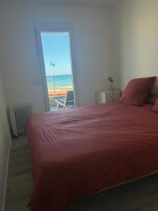 um quarto com uma cama e vista para o oceano em Maison face a la mer em Sainte-Marie-la-Mer