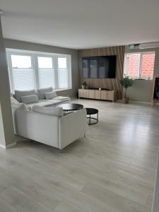 a large living room with a couch and a tv at Large house with 3 bedrooms and a private garden in Stavanger