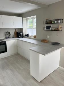 a kitchen with white cabinets and a counter top at Large house with 3 bedrooms and a private garden in Stavanger