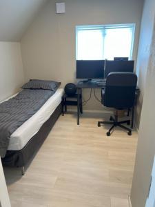 a bedroom with a bed and a desk with a computer at Large house with 3 bedrooms and a private garden in Stavanger