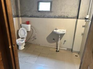 a bathroom with a toilet and a sink at Woodstock in Kalgha