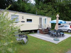 艾瓦耶La caravan-à-JO的移动大篷车,配有桌子和雨伞