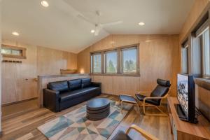 a living room with a black leather couch and chairs at YCC Studio in West Yellowstone