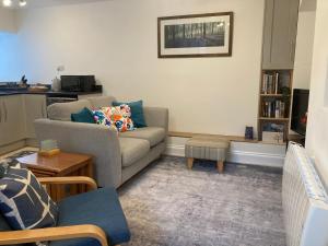 een woonkamer met een bank en een tafel bij Ludford View, riverside cottage in Ludlow with private parking in Ludlow