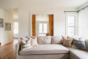 a couch in a living room with white walls at Stay Portland - 2BR Flat - Walk to NW 23rd Shops & Cafes in Portland