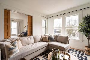 a living room with a couch and two windows at Stay Portland - 2BR Flat - Walk to NW 23rd Shops & Cafes in Portland +9 photos
