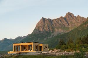 a building with a mountain in the background at Eksklusiv hytte i naturskjønne omgivelser, Lofoten in Storøya