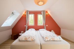 two beds in a room with red walls and a window at L'Authentique Spacieux duplex 2 salles de bains in Haguenau