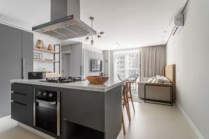 a kitchen with a stove and a counter top at Apto 2 Quartos com Sacada Ed.Jardim Milano in Florianópolis