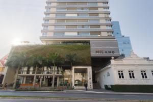 a tall building with a building with a plant at Apto 2 Quartos com Sacada Ed.Jardim Milano in Florianópolis