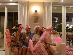 a group of people sitting on a couch in pink costumes at Hotel Tiffany in Rimini +49 photos