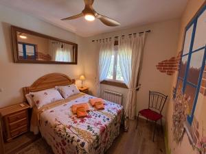 a bedroom with a bed and a ceiling fan at Casa Rural El Fresno in Burgohondo
