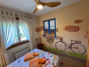 a bedroom with a bed with a bike on the wall at Casa Rural El Fresno in Burgohondo