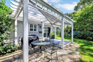 a pergola with a table and chairs on a patio at Secluded 3-Bedroom Retreat in Falmouth in Falmouth