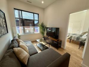 a living room with a couch and a flat screen tv at The Royale Apartments 1 in Trois-Rivières
