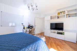 een witte slaapkamer met een blauw bed en een televisie bij Elegante dimora - nel centro di Roma in Rome +6 foto's