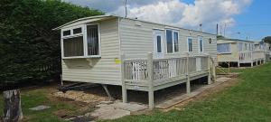 a row of mobile homes parked in a yard at Bailey's Caravan Hire - Sealands Plot 1 - Wi-Fi - Dog Friendly in Ingoldmells