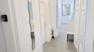 un corridoio con porte bianche e uno specchio sul muro di Cozy rooms in Stadthalle Area HB a Vienna