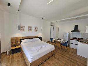 a bedroom with a large bed and a kitchen at Sebi's Chalet with Sea View in Vlorë