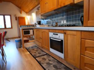 a kitchen with wooden cabinets and a stove top oven at Etage Bleu à la montagne in Saint-Julien-en-Champsaur +12 photos