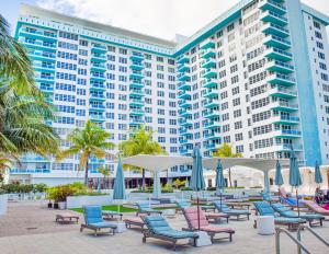 a hotel with chairs and umbrellas in front of a building at Seacoast Suites on Miami Beach in Miami Beach