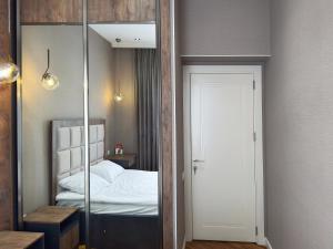 バクーにあるMelissa - Cozy & Great Location in Baku!の鏡付きのベッドルーム1室、ベッド1台が備わるベッドルーム1室を提供しています。