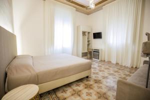a bedroom with a bed and a tv and a couch at Dimora Don Ciccillo B&B in Bagnara Calabra