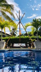 フランデスにあるCoccoloba Hotelのヤシの木が背景に浮かぶスイミングプール