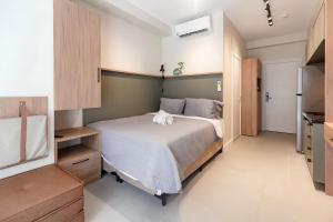 a small bedroom with a bed and a kitchen at Refúgio Moderno no Campo Belo NOVO in Sao Paulo +16 photos