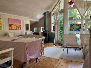 a living room with a table and some windows at 90714-Bogo-By-Hojdedraget-56 in Bogø By