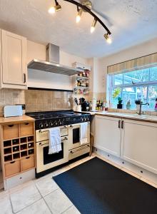 a kitchen with a stove and a sink at Comfy private room in shared house in Cambridge
