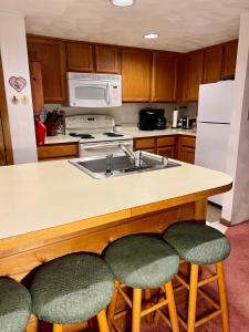 eine Küche mit Spüle und Theke mit Barhockern in der Unterkunft Seven Springs Hideaway Ski In and Out Pet Friendly in Champion + 11 Fotos