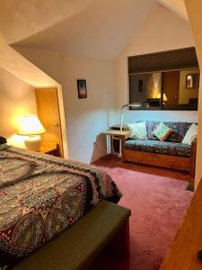 ein Hotelzimmer mit einem Bett und einer Couch in der Unterkunft Seven Springs Hideaway Ski In and Out Pet Friendly in Champion