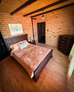 カタマヨにあるCasa familiar La Bendita Rincón Mágicoのレンガの壁、大きなベッド付きのベッドルーム1室