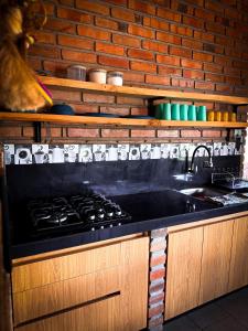 カタマヨにあるCasa familiar La Bendita Rincón Mágicoのレンガの壁、キッチン(コンロ付)