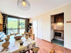 a living room with a table and a kitchen at Résidence Pegase - APPARTEMENT 3 PIECES 7 PERSONNES PISTES MAE-9854 in Le Corbier